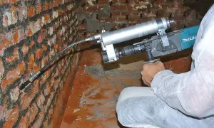 Mauerwerk Injektion selber machen: Gerät zur Rissverpressung an einer Ziegelwand.