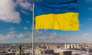 Ukraińska flaga powiewa nad miastem. Chcesz wiedzieć, jak wysłać paczkę na Ukrainę?