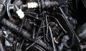 Piezas de coche oxidadas y sucias, como bujías y tornillos, que sugieren la necesidad de remedios caseros para quitar la carbonilla del coche.