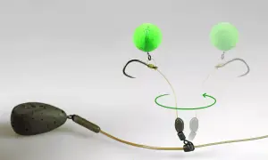 Graskarpfen Montage: Ein Haken mit leuchtend grüner Boilie-Kugel und Blei, bereit für den Fang.
