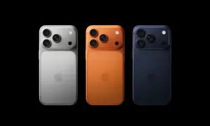 Trzy telefony iPhone w kolorach srebrnym, pomarańczowym i granatowym, z potrójnymi aparatami. Wyglądają jak przyszłe modele, może iPhone 18?