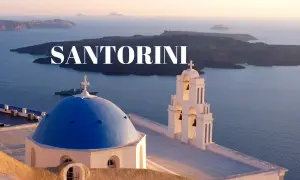 Santorini: błękitna kopuła kościoła i biała dzwonnica na tle kalder. Zobacz, co warto zobaczyć na Santorini!