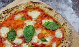 Une Margherita parfaite, symbole de la recette pizza italienne traditionnelle. Sauce tomate, mozzarella fondante et basilic frais sur une pâte dorée.