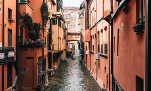 Enge Gasse mit Kanälen und pastellfarbenen Häusern in Bologna. Wie viele Tage würde man hier verbringen wollen?