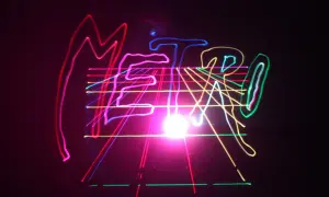 Kolorowe, neonowe linie tworzą napis "METRO" na czarnym tle, przypominając o energetycznym, musical metro.