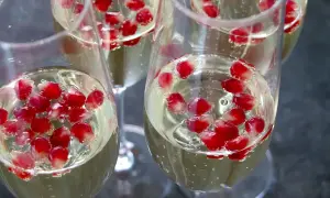 Kieliszki z musującym napojem i nasionami granatu. Idealne do przepisów na drinki z rakija.
