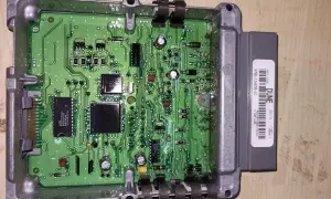 Elektroniczny moduł sterujący silnika Forda, prawdopodobnie z funkcją immobilizera, z widoczną zieloną płytką drukowaną i szarym złączem.