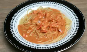 Pâtes au homard crémeuses, un délice servi dans une assiette décorée.