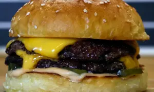 En saftig smashed burger med dubbla köttpuckar, smält ost, pickles och dressing. Perfekt för en hungrig dag!