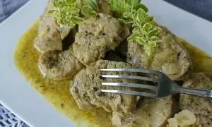 Soczyste polędwiczki w sosie musztardowym, udekorowane świeżymi ziołami. Widelec czeka, by spróbować tego pysznego dania.