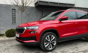 Czerwona Skoda Karoq na tle nowoczesnego budynku. Wiele osób szuka skoda karoq opinie, by podjąć decyzję o zakupie.