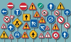 En mängd olika trafikskyltar, som stoppskyltar, varningsskyltar och vägvisningsskyltar, skapar en visuell t-korsning av regler och information.