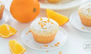 Fanta Muffins mit Puderzucker und Orangenschale, garniert mit frischen Orangenspalten. Ein süßer Genuss!