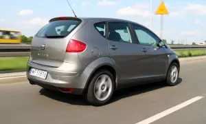 Szary Seat Altea 1.9 TDI w ruchu drogowym, z widocznym znakiem ostrzegawczym.