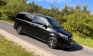 Czarny Mercedes-Benz V-klasa na drodze wśród zieleni.