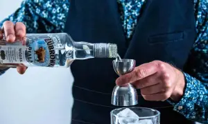 Barman nalewa Żubrówkę do jiggera, przygotowując drinka. Wódki w Polsce to tradycja.