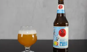 Szklanka z bursztynowym piwem i butelka bezalkoholowego mango ale Browaru Grodzisk.