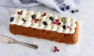 En saftig sockerkaka med yoghurt och bakpulver, toppad med fluffig grädde, blåbär och röda blad.