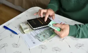 Ręce liczą pieniądze i dokumenty ZUS, przygotowując się do wniosku o rentę z tytułu niezdolności do pracy.