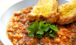 En närbild av en skål med mustig ribollita, toppad med rostat bröd och färsk persilja. Ett perfekt ribollita recept för en kall dag.