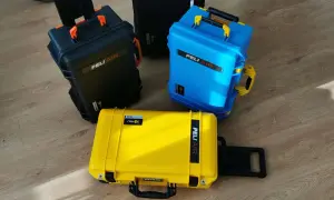 Trzy walizki Peli Air: czarna, niebieska i żółta. Zastanawiasz się, czego nie można mieć w bagażu podręcznym? Te walizki są idealne na sprzęt, który musi być bezpieczny.