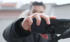 Dłoń trzyma smartfon z zamontowanym uchwytem sp connect, gotowy do nagrywania.