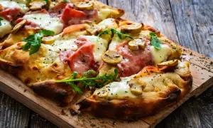 En krispig pinsa med skinka, champinjoner och ruccola. Perfekt för ett snabbt pinsa recept deg.