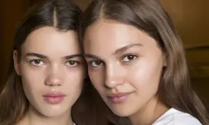 Close-up of two young women with brown hair and natural makeup.