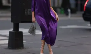 Eleganckie, srebrne sandałki na obcasie idealnie pasują do fioletowej sukienki. Stylizacja na miasto.