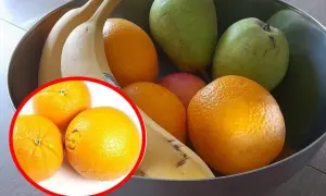 Miska pełna owoców: banany, pomarańcze, gruszki i jabłko. W lewym dolnym rogu zbliżenie na pomarańcze.