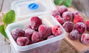 Mrożone truskawki w pojemniku, gotowe do przechowywania. Prosty sposób, jak mrozić truskawki, by cieszyć się nimi przez cały rok.