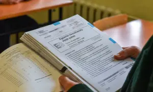 Stos arkuszy egzaminacyjnych z języka polskiego na egzaminie ósmoklasisty.