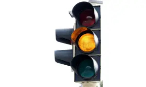 Feu de circulation avec le feu clignotant orange allumé, signalant la prudence.