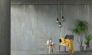 Beton architektoniczny w nowoczesnym wnętrzu. Krzesło z żółtym kocem, stolik z dzbankiem i filiżanką, rośliny.