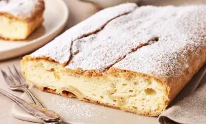 Ein köstlicher Topfenstrudel, bestäubt mit Puderzucker, wartet darauf, probiert zu werden. Dieses Topfenstrudel Rezept ist ein Genuss!
