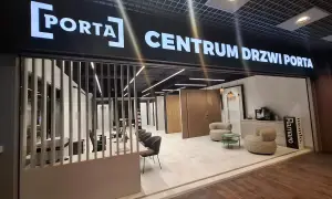 Salon drzwi i okien PORTA z ekspozycją drzwi, meblami i ekspressem do kawy.
