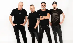 Czterech mężczyzn w czarnych ubraniach, tworzących zespół. Jeden z nich ma na koszulce napis "simply", inny koszulkę z logo Black Sabbath.
