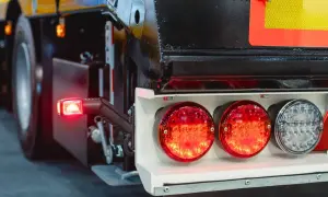 Feux arrière de camion, dont un clignotant rouge allumé. Le système de frein moteur est essentiel pour la sécurité.