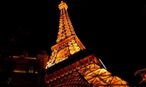 Wieża Eiffla nocą, oświetlona na pomarańczowo. Jej imponująca wysokość robi wrażenie, a napis "Eiffel Tower Restaurant" dodaje uroku.
