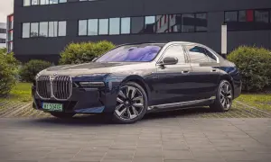 Eleganckie BMW i7 w ciemnym kolorze prezentuje się luksusowo przed nowoczesnym budynkiem.