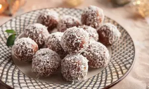 En tallrik med chokladbollar täckta av kokosflingor. Perfekt för ett enkelt chokladbollar recept.