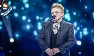 Artysta śpiewa, a na ekranie za nim widać tekst piosenki "Jolka, Jolka pamiętasz".