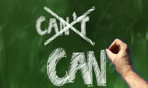 Ręka pisze kredą na tablicy "CAN", przekreślając "CAN'T". Koniec z postawą osoby pasywnej!