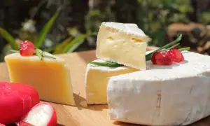 Olika ostar, inklusive brie och en hårdost, dekorerade med granatäppelkärnor och gräslök. Perfekt för en ostbricka, kanske till och med för en gravid som längtar efter mozzarella.