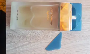 Perfumy Dolce & Gabbana Light Blue, w odcieniu niebieskim, na drewnianym tle.