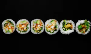 Sześć kawałków futomaki, czyli dużych rolek sushi, z awokado, warzywami i smażonymi kawałkami.