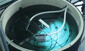 Ein großer Tank mit Wasser, Rohren und einem Gerät zur Eisbildung. Hier wird ein **Eisspeicher selber bauen**-Projekt umgesetzt.