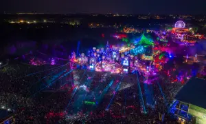 Nocny festiwal Tomorrowland 2026 w pełni. Tłumy ludzi, kolorowe światła, sceny w kształcie zamków i latające balony tworzą magiczną atmosferę.