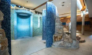 Moderne Duschen mit Mosaikfliesen und Felsenelementen in der Therme Regensburg laden zum Entspannen ein.