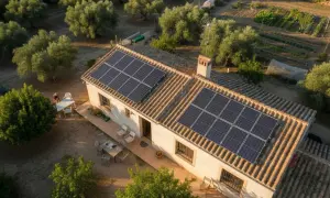 Casa rural con paneles solares en el tejado, ideal para el cálculo del consumo eléctrico. Rodeada de olivos y huerto.